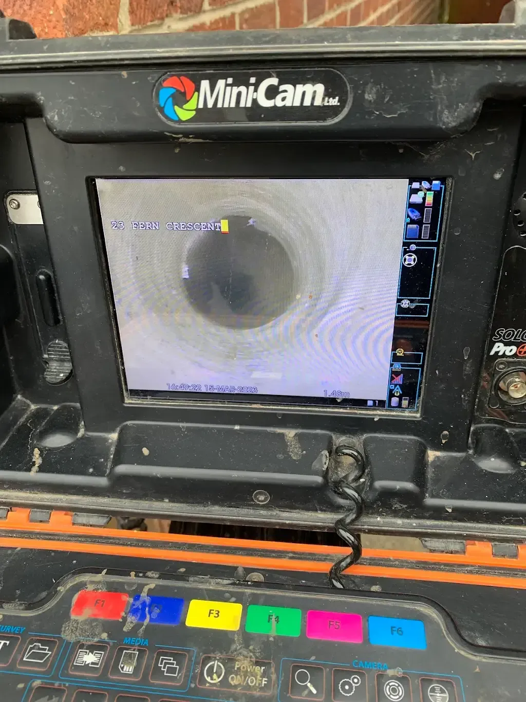 A CCTV drain survey monitor displaying an internal view of a drainage pipe during a professional inspection.